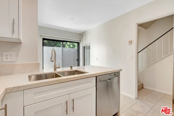 a kitchen with stainless steel appliances granite countertop white cabinets a stove top oven