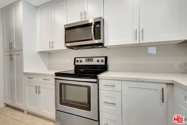 a kitchen with a sink a refrigerator and cabinets