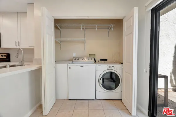a kitchen with white cabinets and refrigerator