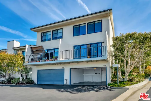 a view of a swimming pool with lawn chairs under an umbrella