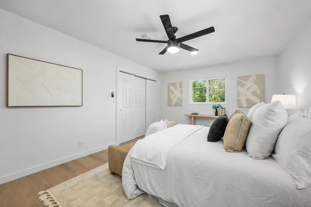 a spacious bedroom with a bed and a chandelier