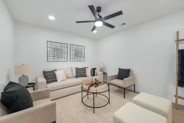 a living room with furniture a rug kitchen view and a window
