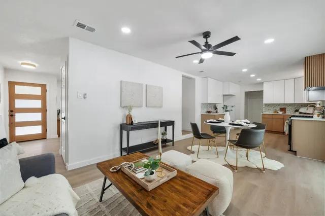 a living room with furniture kitchen view and a potted plant