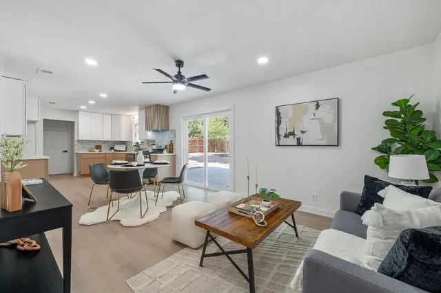 a kitchen with a dining table chairs and white cabinets