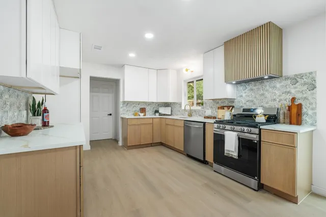 a large kitchen with stainless steel appliances lots of counter space and a sink