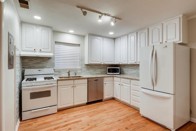 Large kitchen could accommodate a small island.  White cabinetry blends perfectly with appliances, including gas cooktop/oven.