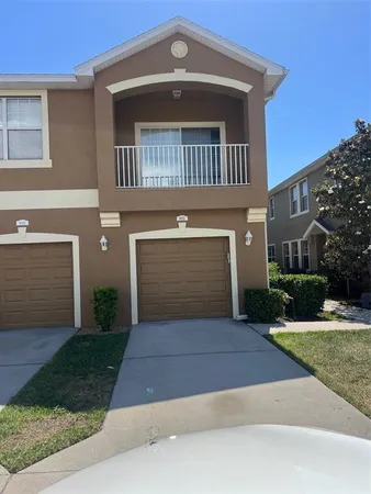 a front view of a house with yard and parking
