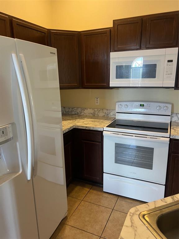 9122 Moonlit Meadows Loop, Unit 1 Riverview, FL 33578 - Photo 5 of 13 a kitchen with granite countertop a refrigerator and a stove