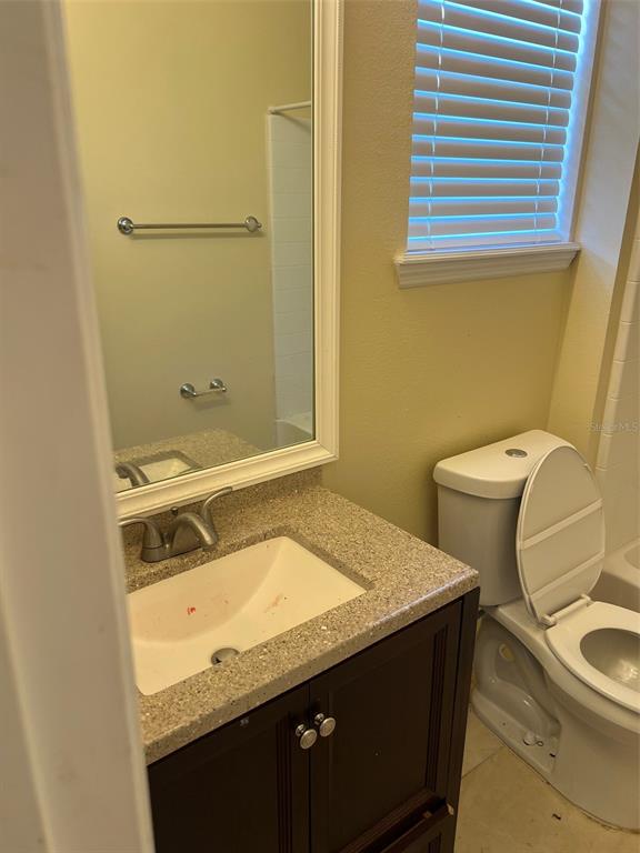 9122 Moonlit Meadows Loop, Unit 1 Riverview, FL 33578 - Photo 8 of 13 a bathroom with a granite countertop sink toilet and a mirror