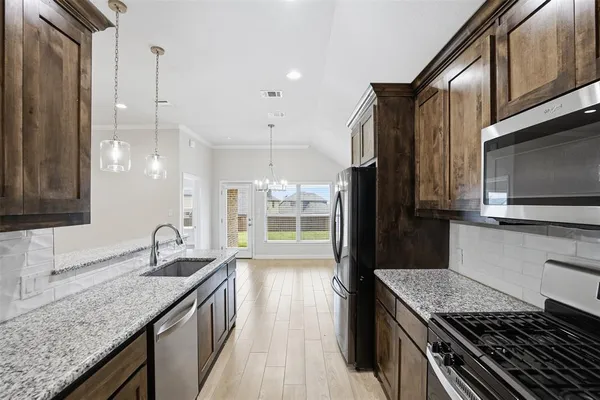 a kitchen with granite countertop stainless steel appliances and wooden cabinets