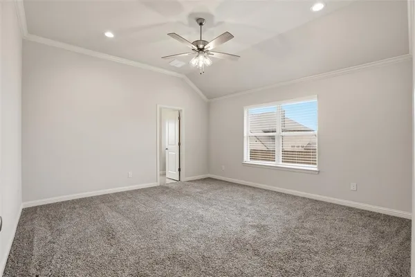 an empty room with chandelier fan and windows