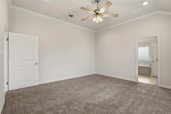 an empty room with a bathroom and a ceiling fan