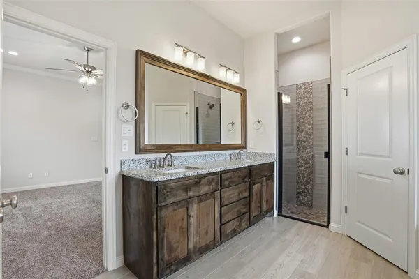a bathroom with a granite countertop sink a mirror and a shower