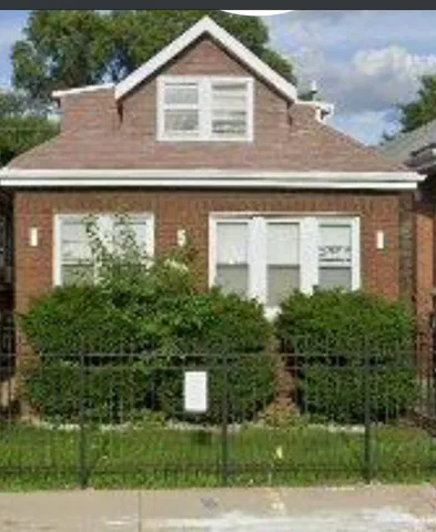 a front view of a house with plants and trees
