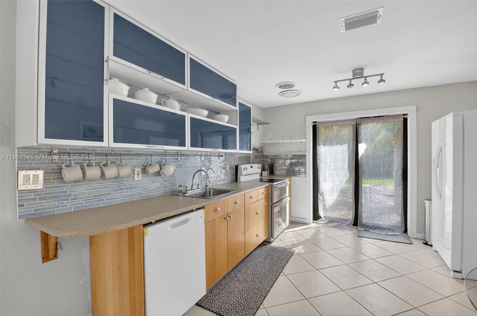 5172 Pine Tree Drive Delray Beach, FL 33484 - Photo 12 of 59 a large kitchen with a sink and a refrigerator