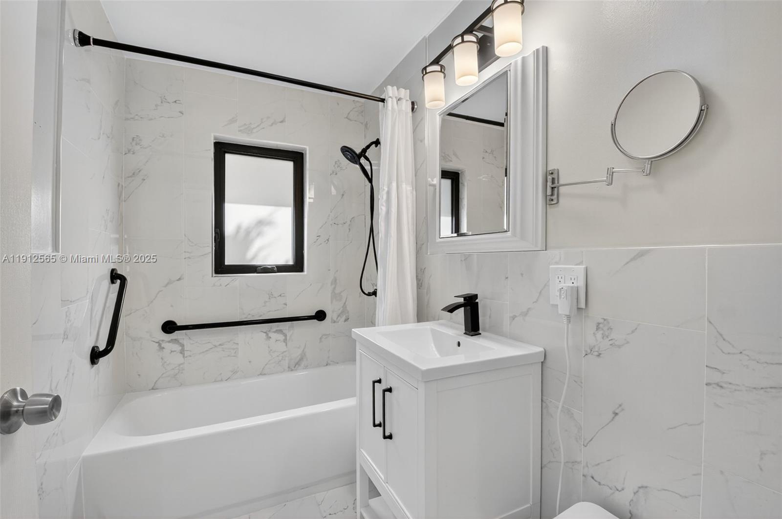 5172 Pine Tree Drive Delray Beach, FL 33484 - Photo 22 of 59 a bathroom with a tub a sink and a mirror