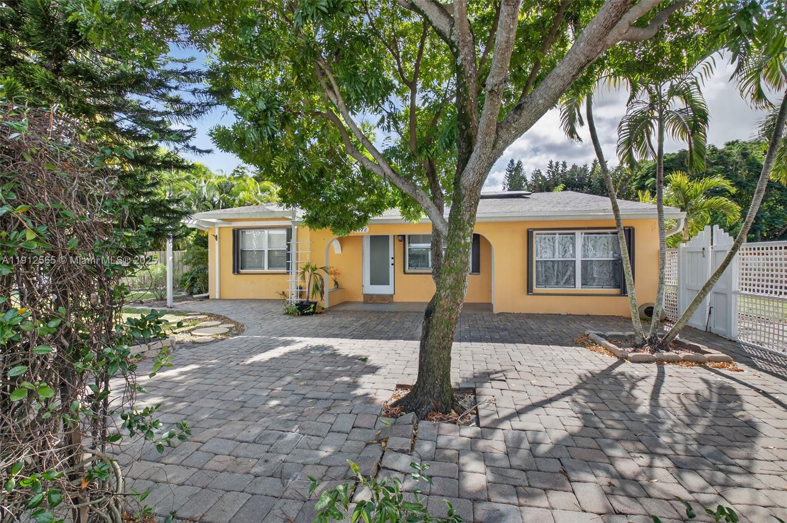 5172 Pine Tree Drive Delray Beach, FL 33484 - Photo 23 of 59 a front view of a house with a tree