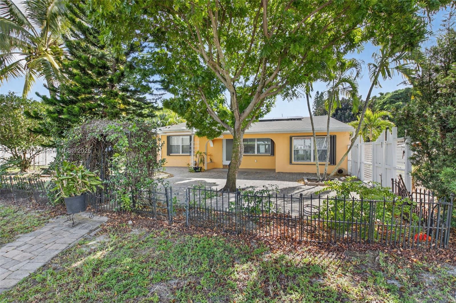 5172 Pine Tree Drive Delray Beach, FL 33484 - Photo 24 of 59 a front view of a house with garden