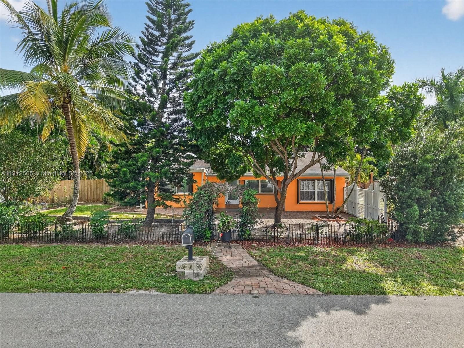 5172 Pine Tree Drive Delray Beach, FL 33484 - Photo 26 of 59 a front view of a house with a garden