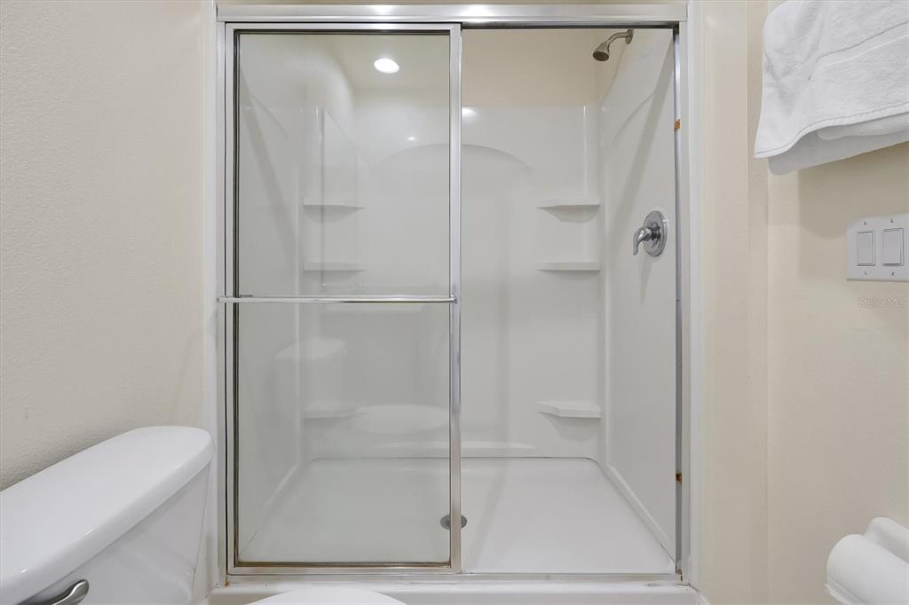 3011 Red Ginger Road Kissimmee, FL 34747 - Photo 27 of 62 a bathroom with a glass shower door