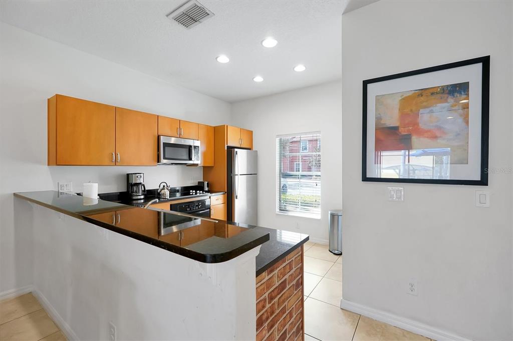 3011 Red Ginger Road Kissimmee, FL 34747 - Photo 7 of 62 a kitchen with stainless steel appliances a sink a stove a refrigerator cabinets and a dining table