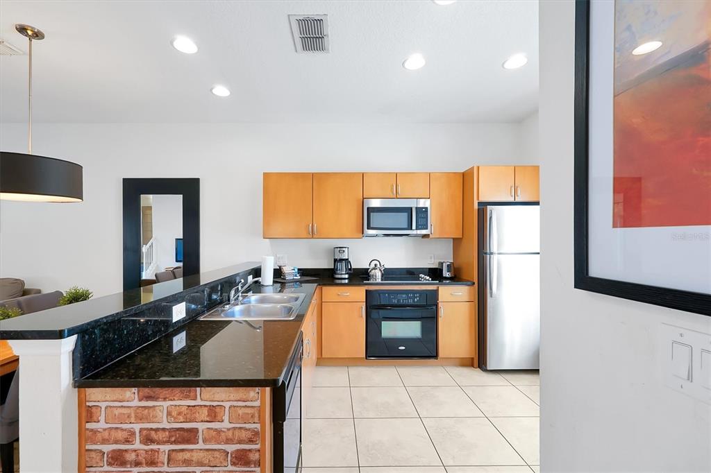 3011 Red Ginger Road Kissimmee, FL 34747 - Photo 8 of 62 a kitchen with stainless steel appliances granite countertop a stove a sink and a refrigerator