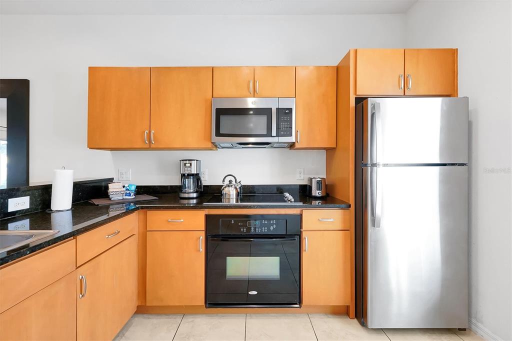3011 Red Ginger Road Kissimmee, FL 34747 - Photo 9 of 62 a kitchen with stainless steel appliances granite countertop a refrigerator a stove a sink and a microwave