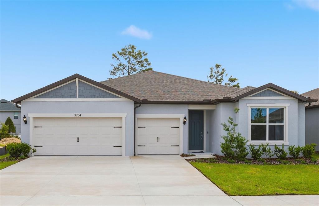 a view of a house with a yard and garage