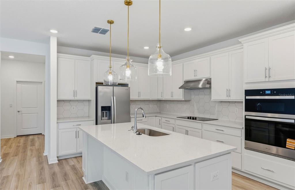 3734 Obsidian Drive Spring Hill, FL 34609 - Photo 3 of 25 a kitchen with a sink a stove a refrigerator and cabinets