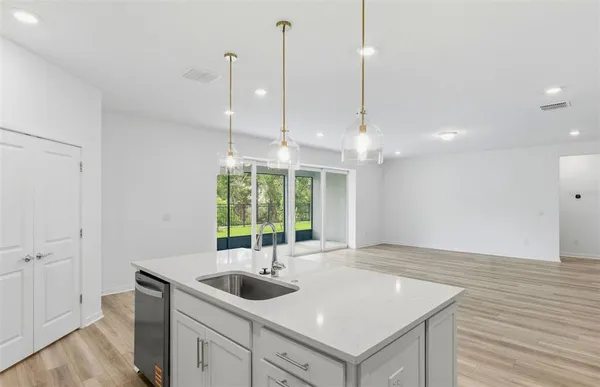 a kitchen with a sink window and wooden floor