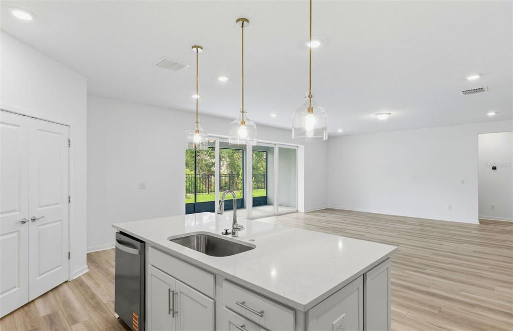 3734 Obsidian Drive Spring Hill, FL 34609 - Photo 4 of 25 a kitchen with a sink window and wooden floor