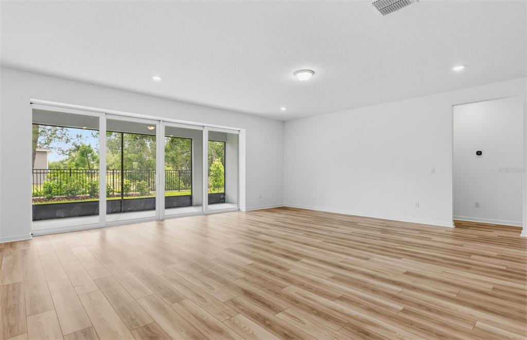 3734 Obsidian Drive Spring Hill, FL 34609 - Photo 6 of 25 a view of an empty room with wooden floor and a window