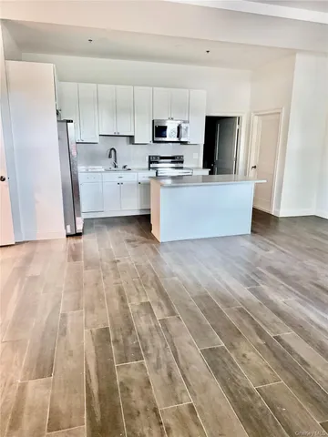 a view of kitchen with wooden floor and electronic appliances