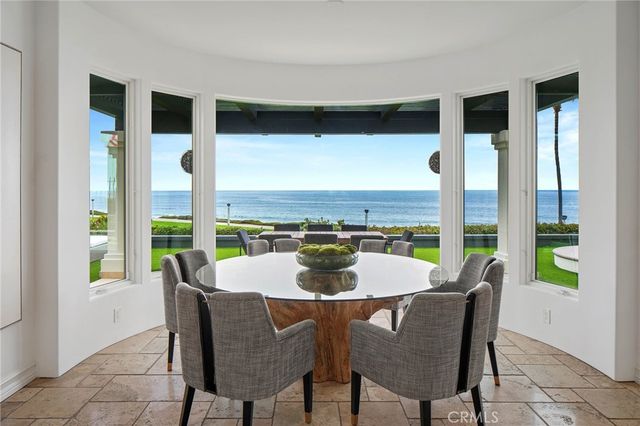 a dining room with furniture large windows and a rug
