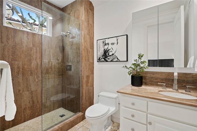 a bathroom with a granite countertop sink a toilet and shower