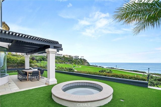 a view of a swimming pool with lawn chairs under an umbrella