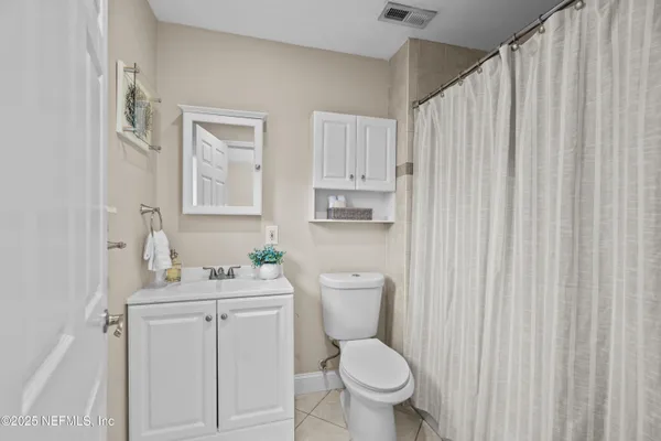a bathroom with a toilet sink vanity and mirror