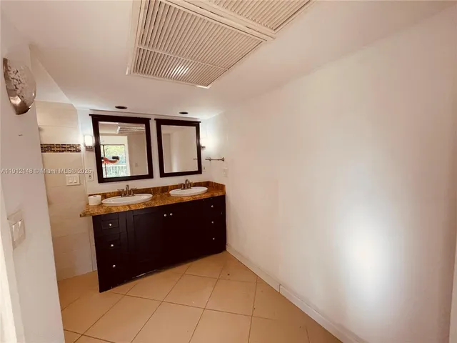 a spacious bathroom with a granite countertop sink and mirror
