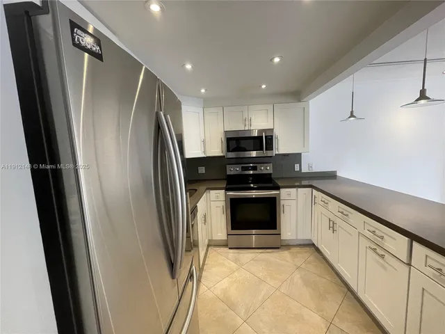 a kitchen with stainless steel appliances a refrigerator sink and microwave