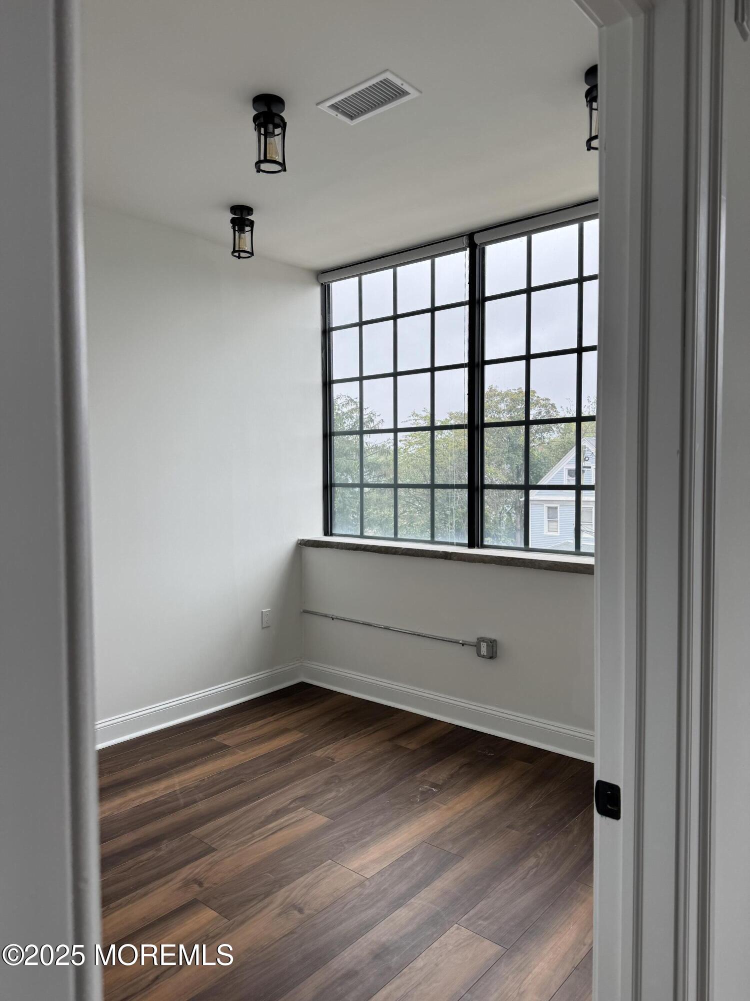 179 Chelsea Avenue, Unit 201 Long Branch, NJ 07740 - Photo 2 of 6 a view of empty room with wooden floor and fan