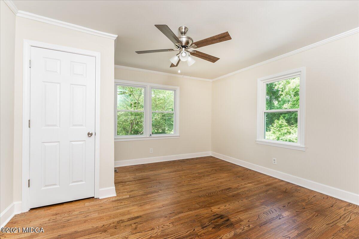5611 Sardis Church Road Macon, GA 31216 - Photo 14 of 32 an empty room with wooden floor a ceiling fan and windows