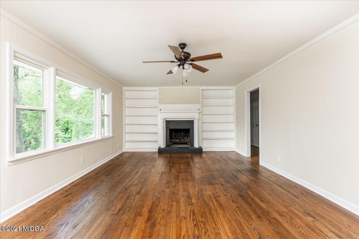 5611 Sardis Church Road Macon, GA 31216 - Photo 18 of 32 a view of a livingroom with a fireplace a ceiling fan and wooden floor