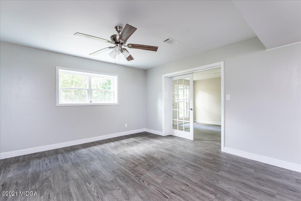 5611 Sardis Church Road Macon, GA 31216 - Photo 24 of 32 a view of an empty room with wooden floor and a window