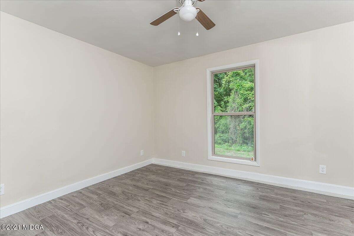 5611 Sardis Church Road Macon, GA 31216 - Photo 29 of 32 an empty room with wooden floor fan and windows