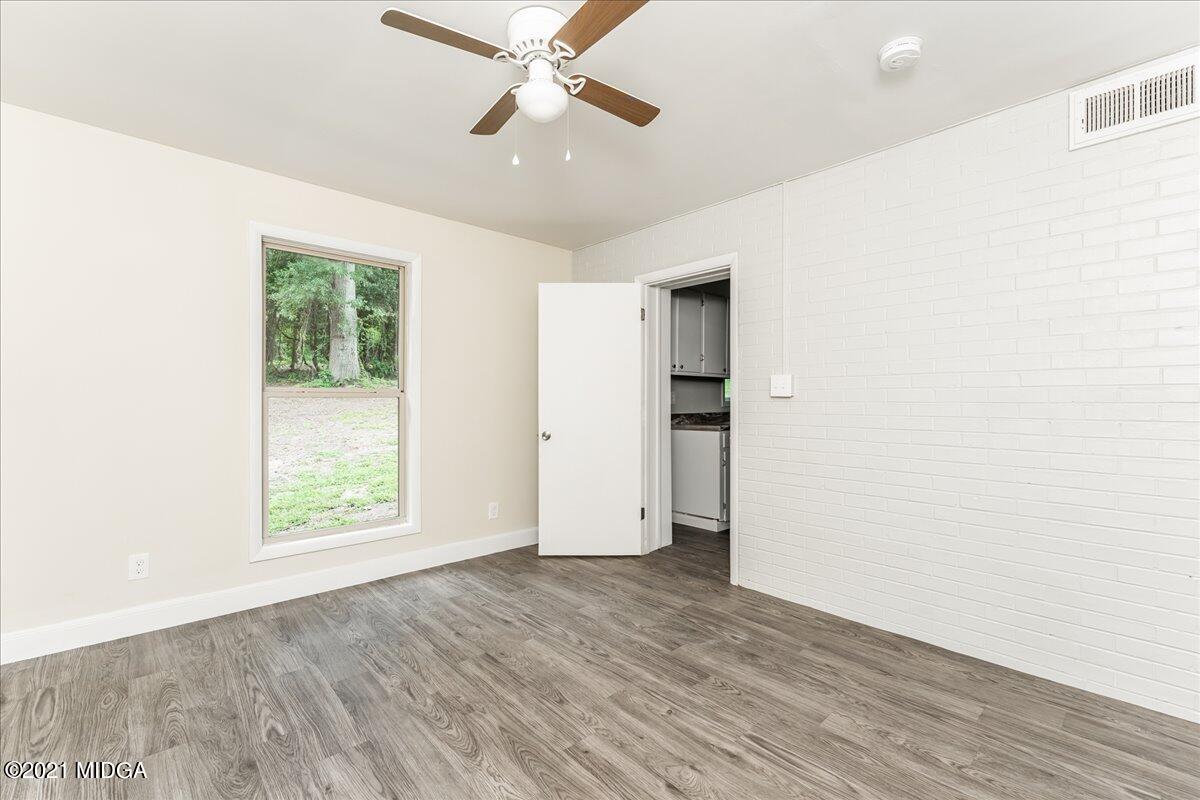 5611 Sardis Church Road Macon, GA 31216 - Photo 30 of 32 an empty room with wooden floor chandelier fan and windows