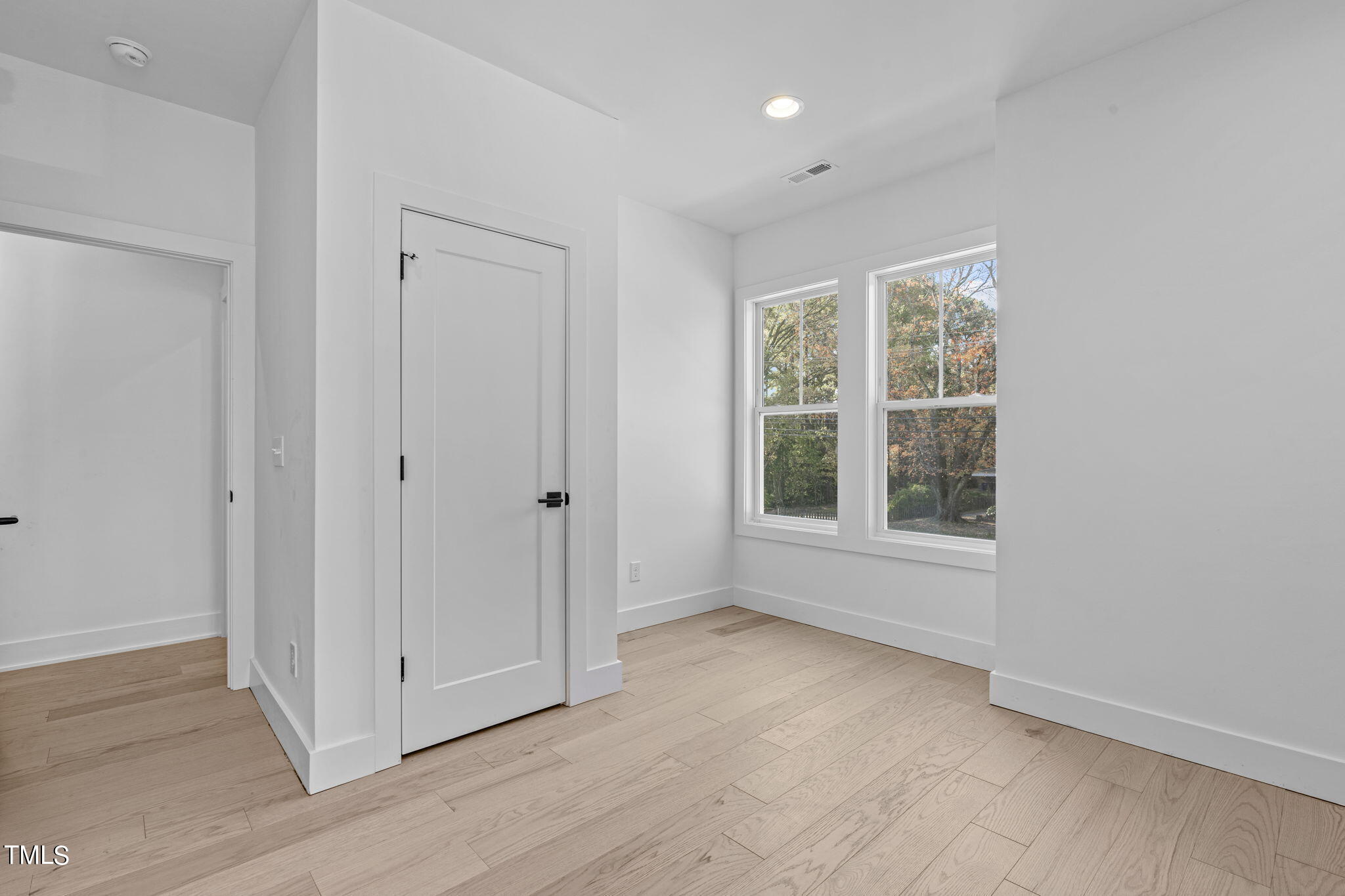 901 Athens Drive, Unit 101 Raleigh, NC 27606 - Photo 44 of 62 an empty room with wooden floor and windows