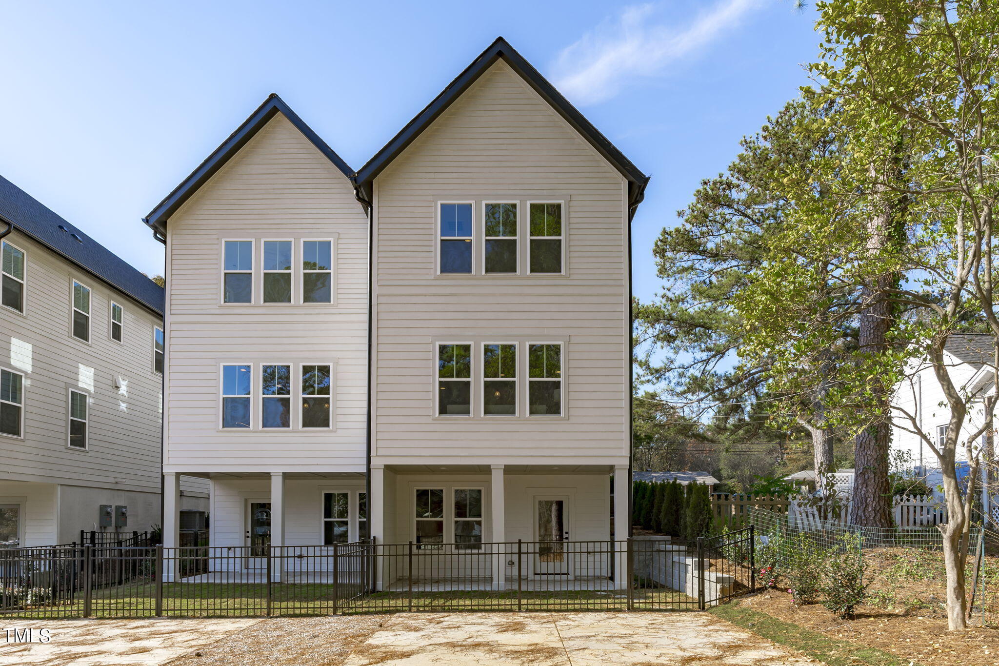 901 Athens Drive, Unit 101 Raleigh, NC 27606 - Photo 47 of 62 a view of a brick house with large windows and a tree