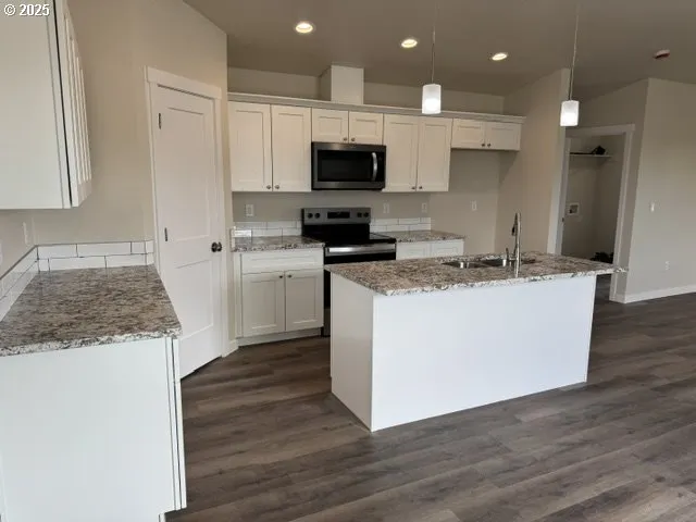 a kitchen with granite countertop a sink and a stove top oven