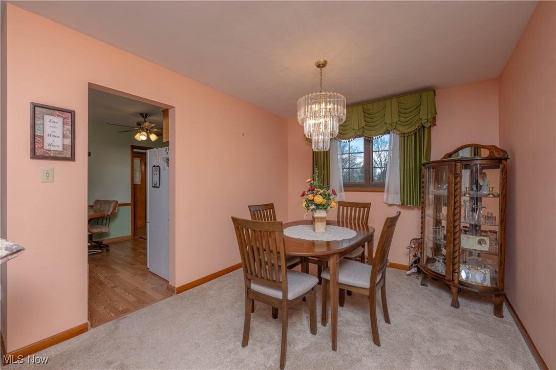 3205 Hemphill Road Barberton, OH 44203 - Photo 9 of 22 Dining room featuring ceiling fan with notable chandelier and light hardwood / wood-style flooring