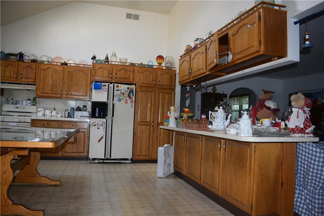 4035 Devonshire Road Bethlehem, PA 18020 - Photo 5 of 19 Vaulted ceilings soar over a spacious kitchen workspace featuring abundant wooden cabinetry.
